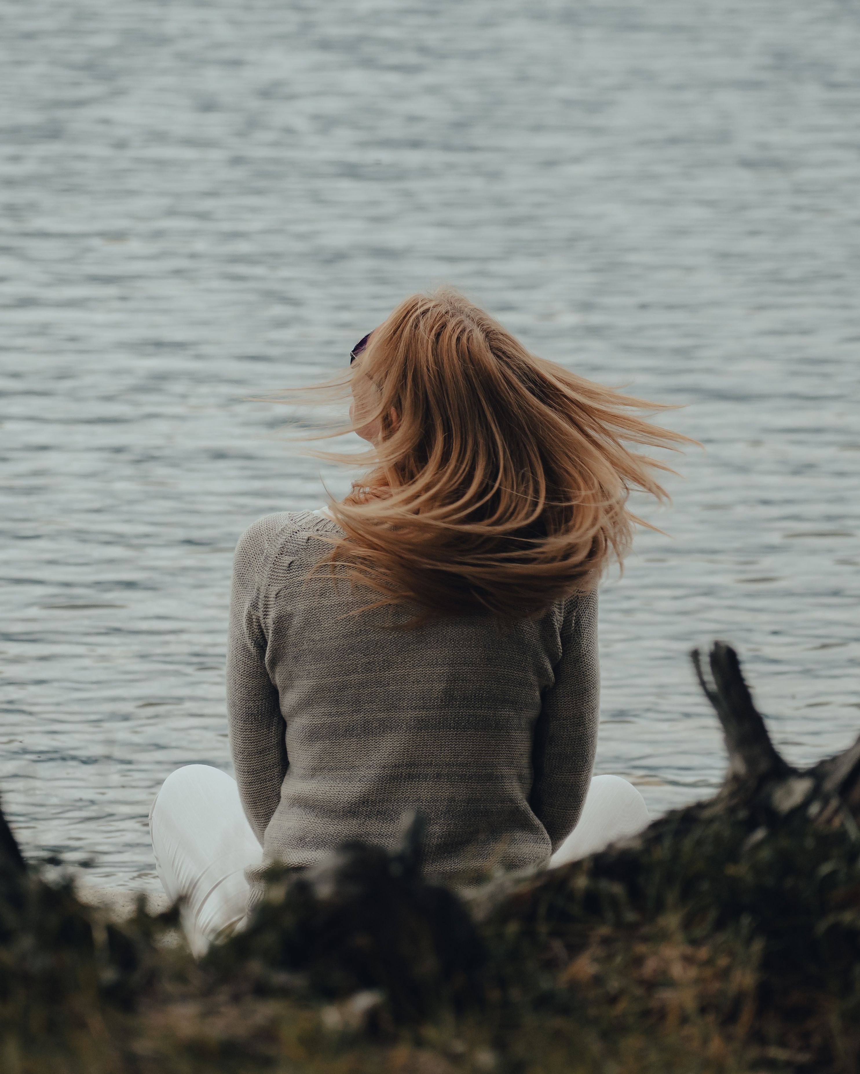 A woman sitting beside a lake